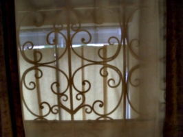 [picture: Wrought iron through net curtains]